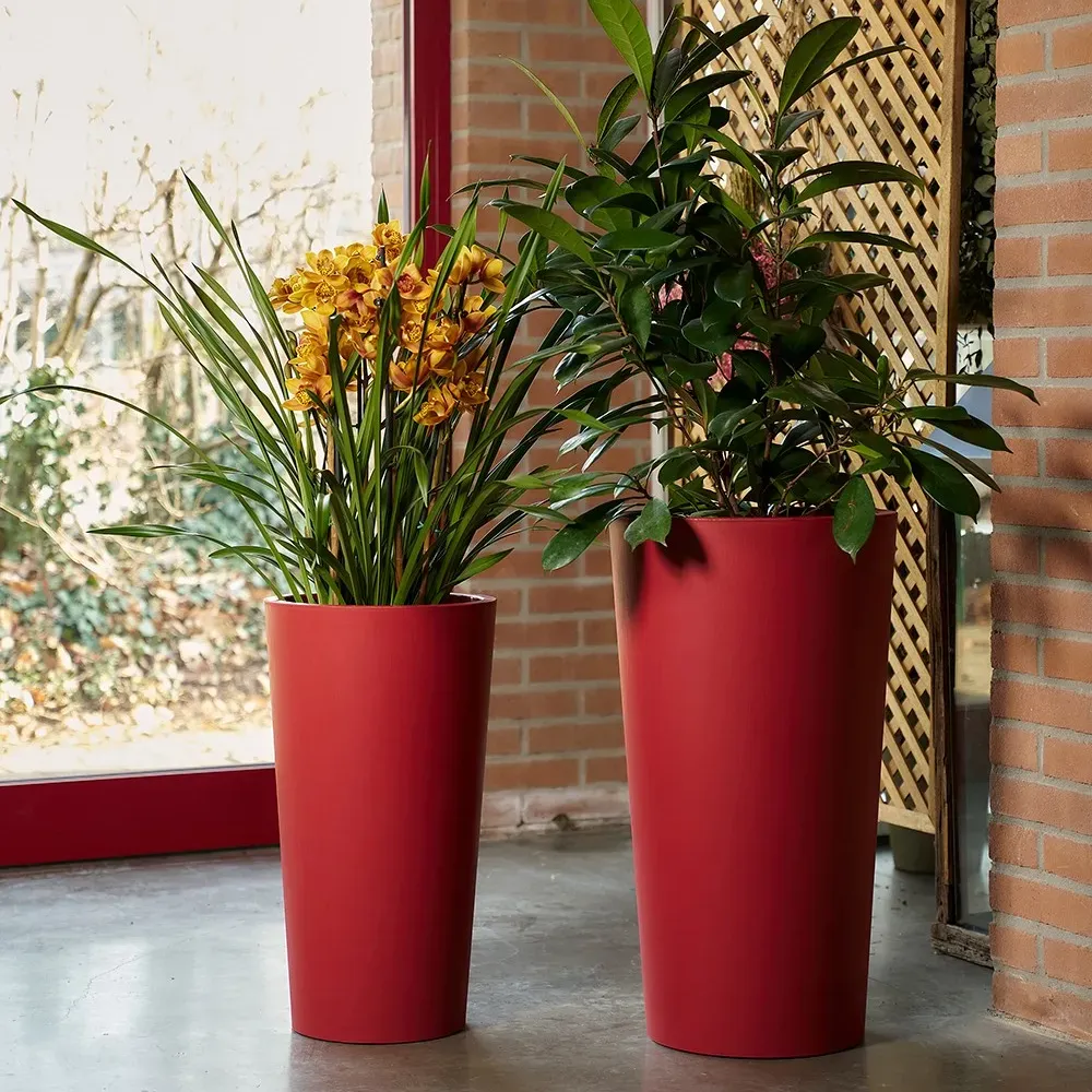 Zwei TUIT RAW Pflanztöpfe, in der Farbe rot, unterschiedlicher Höhe im Wohnraum